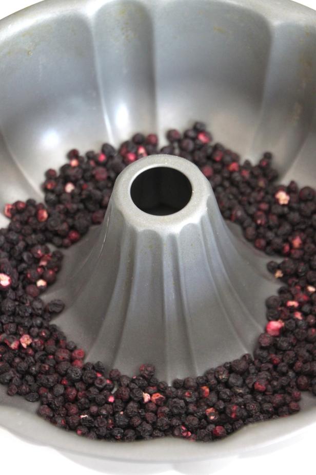 Add berries and dried fruit to the bundt pan. Add berries and dried fruit to the bundt pan.