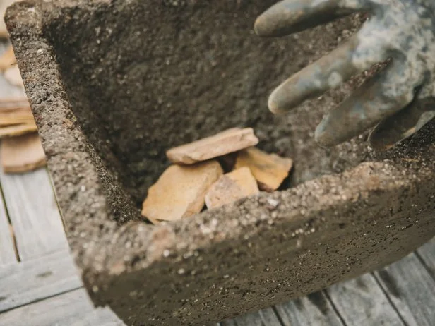 Place rocks or broken pots/slate in the bottom of your hypertufa pot.