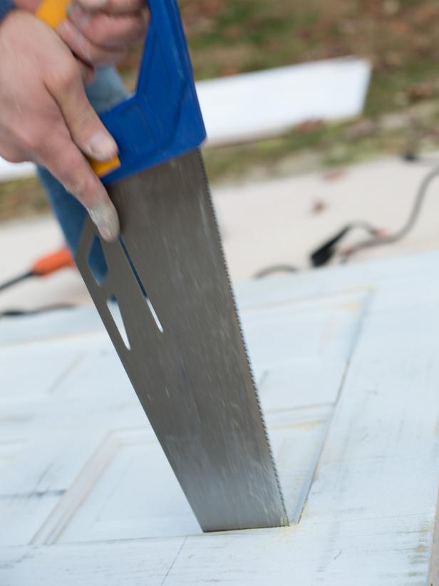 Once the majority of the side panels have been cut out, remove any leftover wood corners with the hand saw.
