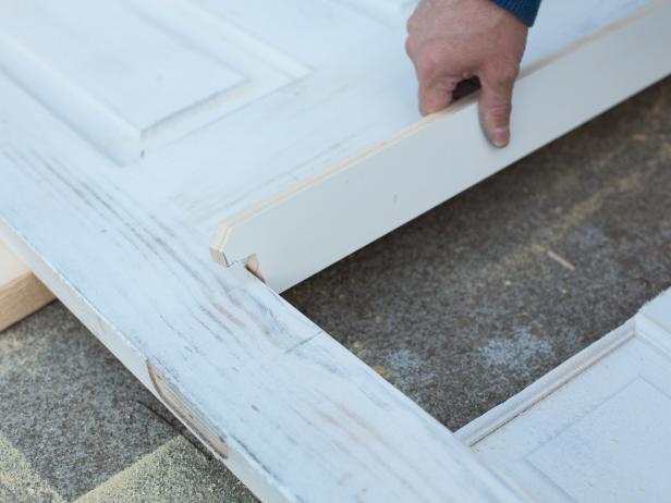 Use a hand saw to cut the strip, then place it along the bottom of the door opening. Secure the ledge into place using wood glue, nails and a hammer. For a more decorative look, add pressure-treated crown molding under ledge.