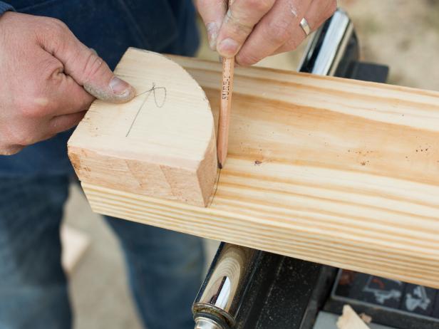 Create a quarter circle template by tracing a round edge onto two pieces of scrap pine or cedar boards, then cut the pattern onto the 2' x 6' plank.
