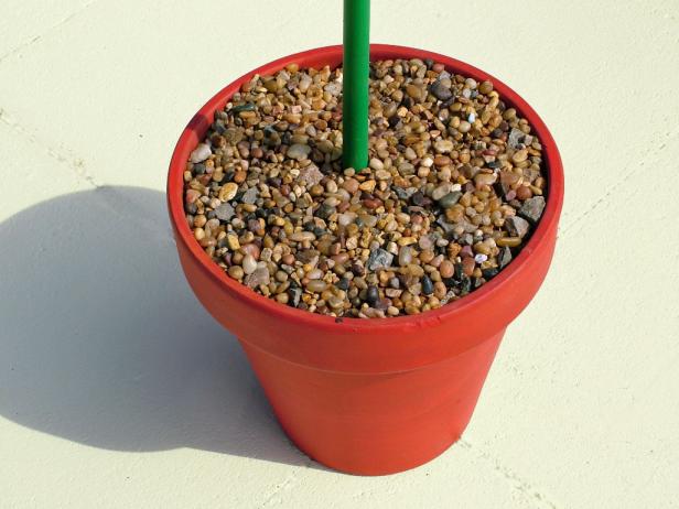 A terra cotta pot filled with colored stones and pebbles will be used as the base for a homemade sun dial.
