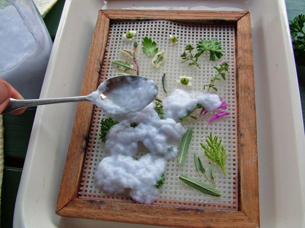 To finish the collage, spoon prepared pulp around and over the leaves, flowers or stems.