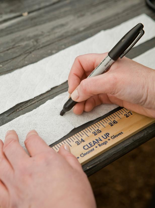Consult the packet of seeds to find out how far apart the seeds should be planted, then use marker or pen to mark each spot where a seed will go.