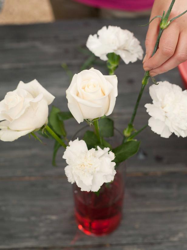 Drop the flower stems into the colored water. Let the flowers remain in their color baths for at least 24 hours. Depending on how quickly your flowers slurp up their water, you might need to add more water and color. Full color may not develop until 48 hours.