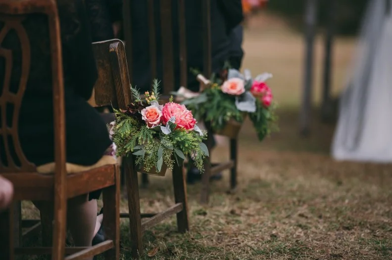 These beautiful blooms lined the aisle at the ceremony where guests sat in a collection of antique wooden chairs.&nbsp;