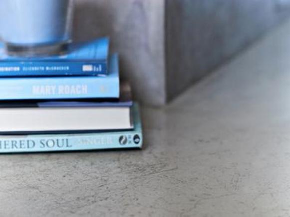 Books, candles and cool concrete tub surround.