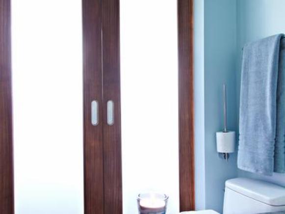Bathroom's frosted glass doors permit room to flood with diffused light.