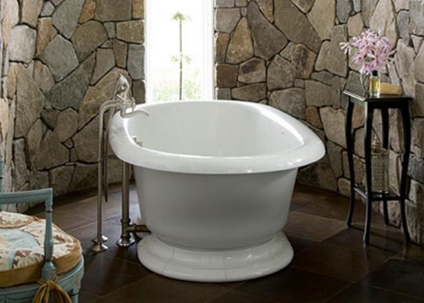 Those walls! The curves and the fieldstone tile give this bathroom a warm, rustic feel thatâ  s balanced perfectly with the glamour of the tub and chandelier. Iâ  ve been seeing more stone as tile lately but this scale is so dramatic. Iâ  d almost welcome a hard day, just to have an excuse to come home and soak in this tub. Fieldstone, take me away!