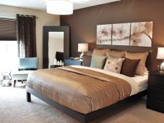 A dark, rich, chocolate-brown accent wall sets the tone for this modern yet romantic master bedroom.