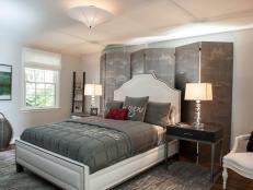 A bedroom designed for the traveling guest, Wendy Danziger of Danziger Design overcame room challenges by commissioning a custom screen by Billet Collins to hide an off-center window and enhance the room's silvery gray and white color scheme. French memo boards cover the closet doors, while tourist info on inside shelves and a doggy bed for the traveling pet complete a cozy place to call home if only for a while. Photography by Robert Radifera/DC Design House