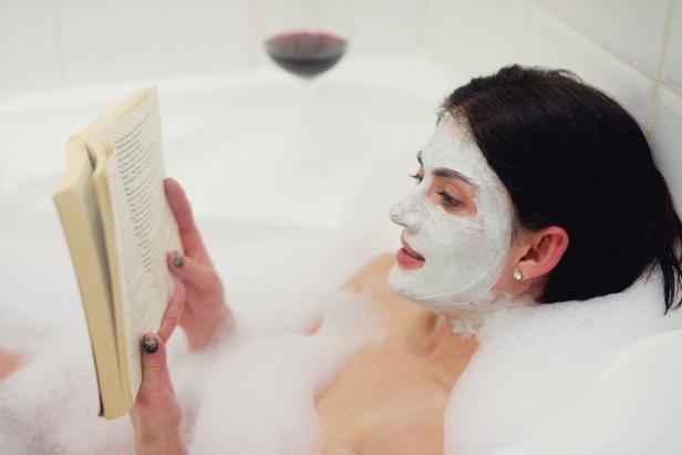 Woman Reading in Bath with Face Mask Woman Reading in Bath with Face Mask