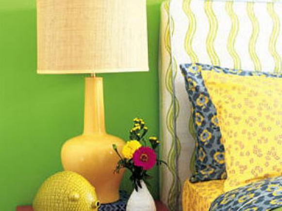 Yellow Lamp On a Pink Night Stand Against a Green Wall
