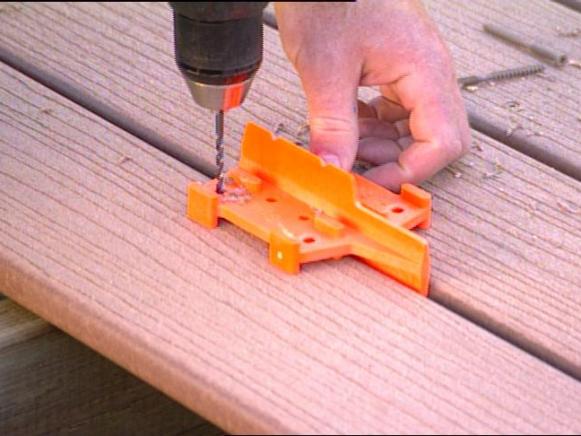 Man using a deck guide to align holes for drilling.