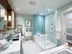 Pale Green Bathroom With Glass Shower and White Vanity Countertops