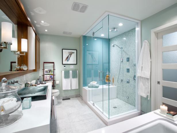 Pale Green Bathroom With Glass Shower and White Vanity Countertops