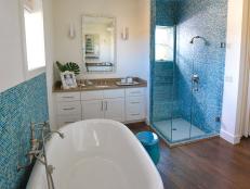 Glass tile in a stunning sea blue serves as the inspiration for this spa-like space, complete with vintage-style soaking tub and glass-enclosed shower.