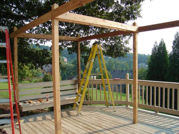 Step 6: Measure and cut 2-by-8-inch cedar lumber to frame the outside of the posts, plus a pair of 2x8s to go between the center posts. The louvered panels will fit snugly inside these frames. Tip: Use a jigsaw to cut a decorative edge on the ends of the long beams and attach the beams to the tops of the posts with lag bolts.
