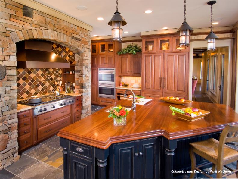 Traditional Kitchen With Wood Cabinets, Stone Wall and Black Island