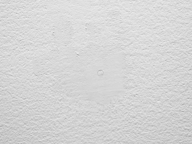 Spackle any holes in the wall surface and smooth with sandpaper before applying the wallpaper.