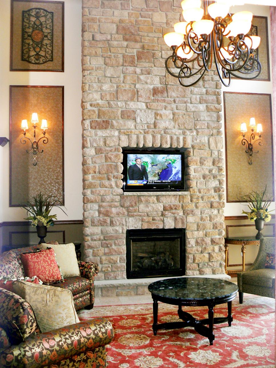 Stone Fireplace Wall With Wall Frame Molding and Sconces