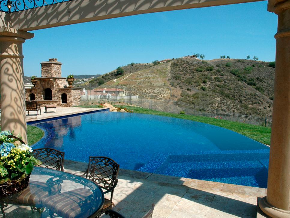 Contoured Infinity Pool With Outdoor Fireplace and Hillside View