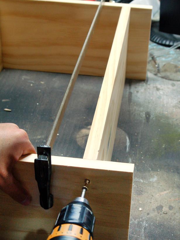 Use diagram as a guide and loosely assemble the cabinet on a flat surface. Working top to bottom, line up shelf edges perfectly with pencil marks. The bottom shelf should be positioned two inches from the bottom of length pieces to leave room for the installation cleat. This 2-inch gap will be covered by base molding. Holding shelf firmly in one hand, drill pilot holes.
