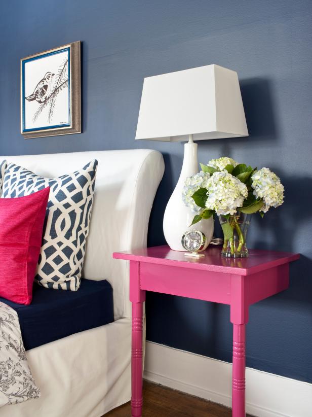 Blue Bedroom With Half Pink Nightstand, White Lamp and White Flowers