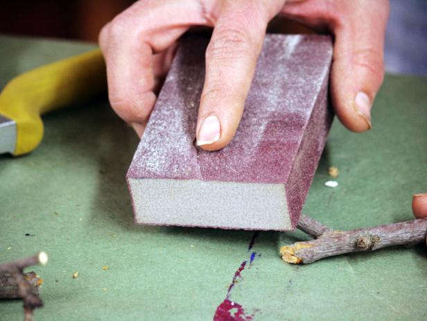 Use a sanding block to smooth the branch before using it for the homemade branch necklace project.