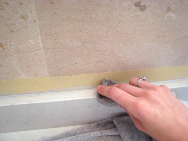 Use a straight blade to remove any large pieces of excess caulk. A rag with acetone will help further smooth the seams and clean up any residue from the caulk.