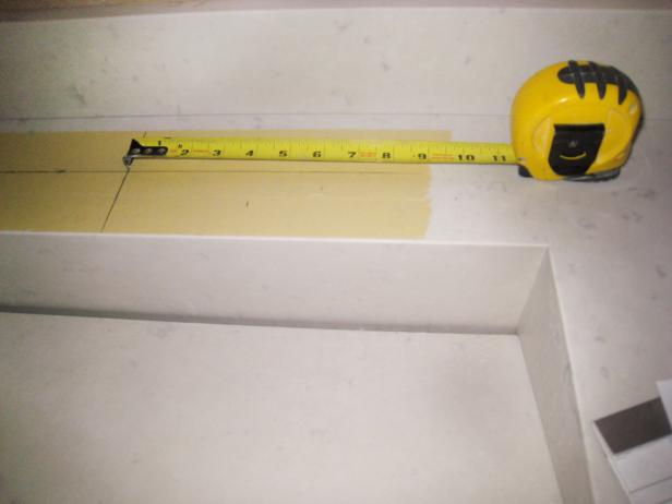 Lay masking tape along the back of the sink where the faucet and handles will be placed. Measure to the centerline where the faucet will be located. Mark the tape for the holes that are needed to hook up the plumbing fixtures. An 8" spread between handles is standard, but it can be as little as four inches, depending on the fixtures used. See the installation guide for information specific to your product.