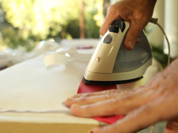 Ironing Red Ribbon on White Fabric