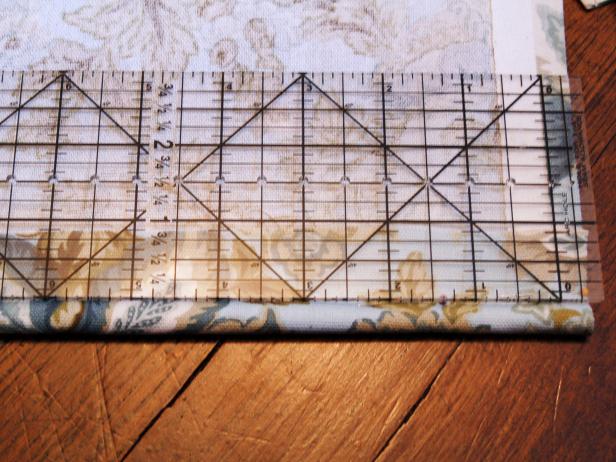 Insert dowel rod in fold and pin fabric to form pocket. Using a yardstick or ruler, measure distance between every other ring on tape