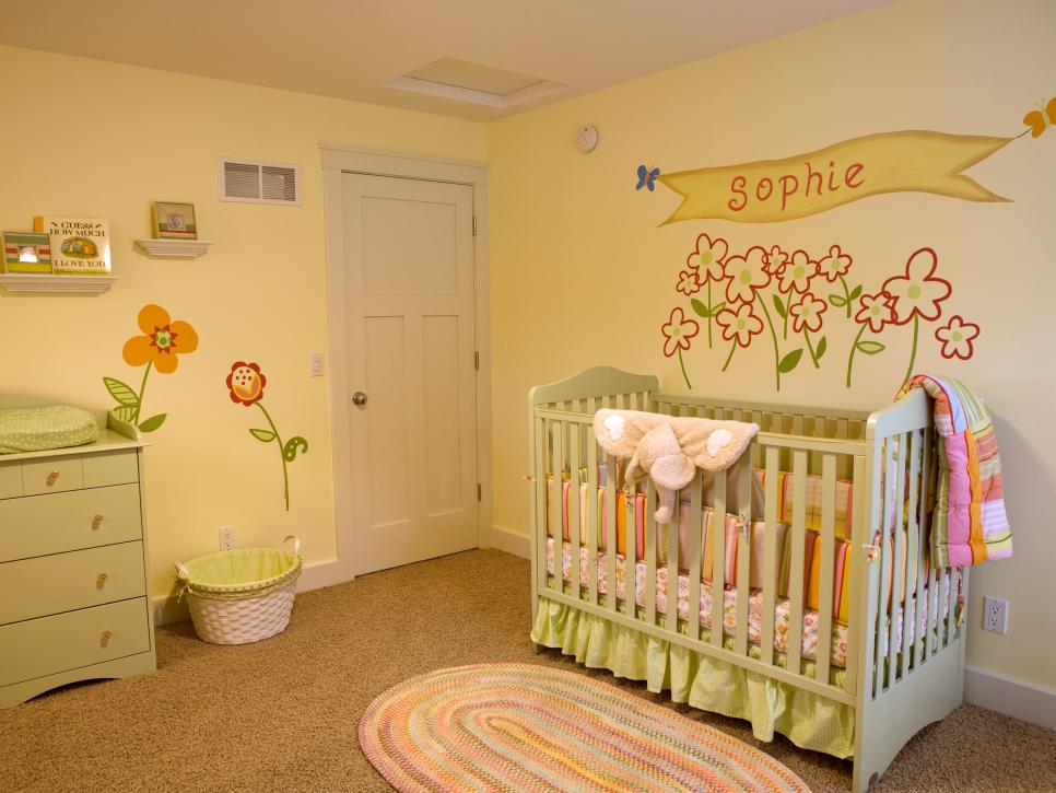 Yellow Nursery With Green Crib, Woven Rug and Flowers on Wall