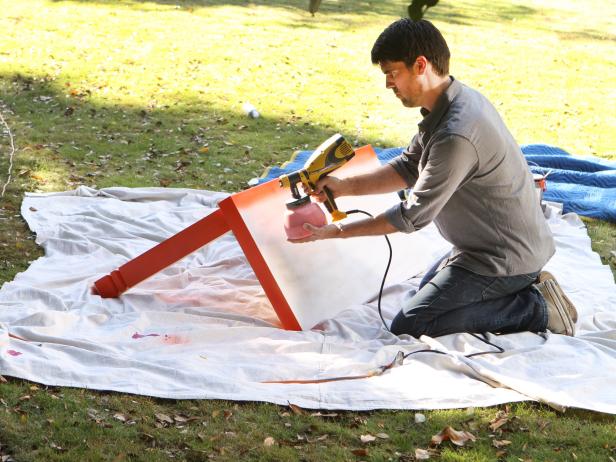 Man Spraying Paint Onto Desk