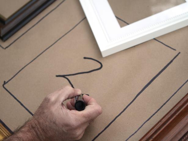 Trace each frame's dimensions onto paper using pencil or marker. Identify each frame by adding a piece of numbered painter's tape to the back. Tip: For uniformity, leave approximately the same amount of space between each frame.