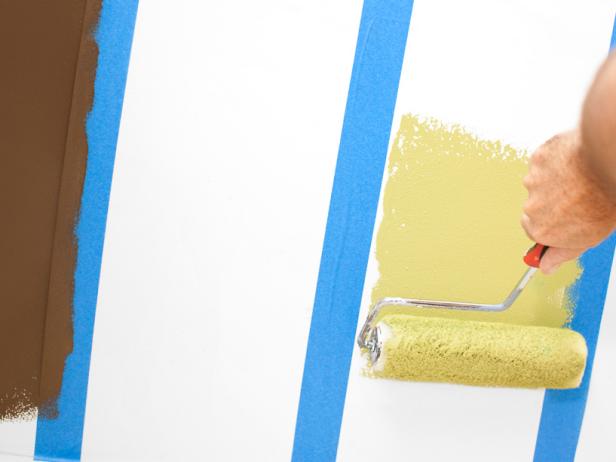 Before painting, protect the floor and any furnishings with a drop cloth. Starting from the edge of the tape, working inward, paint each taped-off area with the accent color. After two coats of the first accent color are dry, place a new liner into your pan before pouring the next color. For side-by-side, two-tone stripes, reposition the tape along the inside line of the completed stripe, then roll between newly positioned tape.
