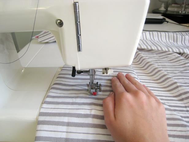 Woman Sewing Hem of Striped Fabric