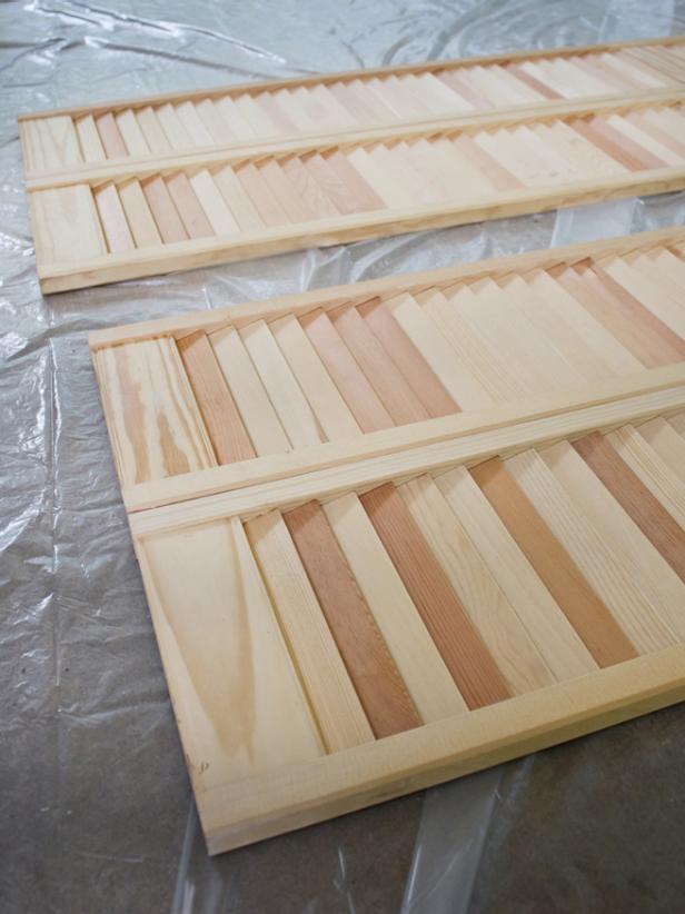 Place the shutters on a large plastic drop cloth to prepare for painting.