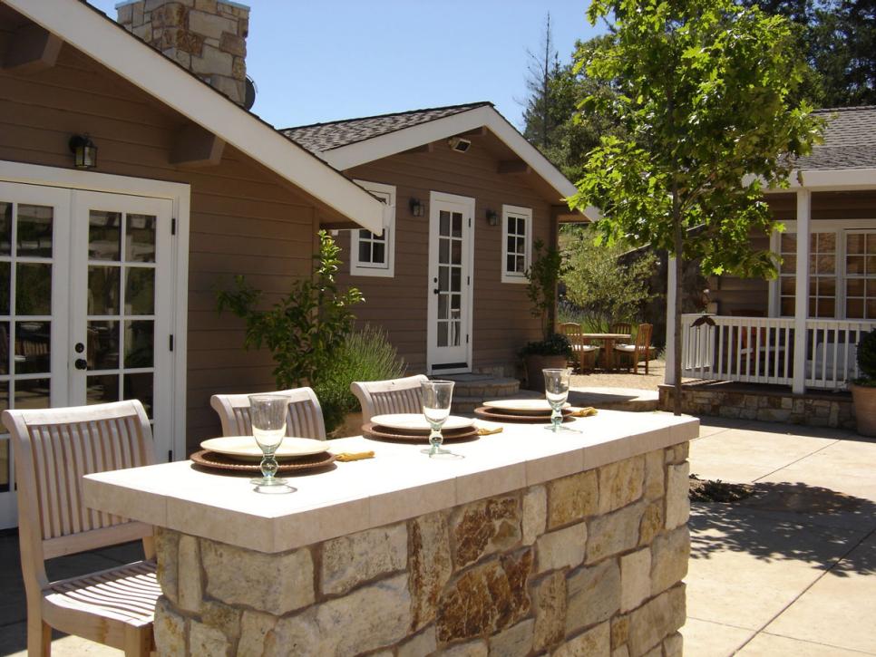 Stone Bar With Three Barstools in Cottage Courtyard