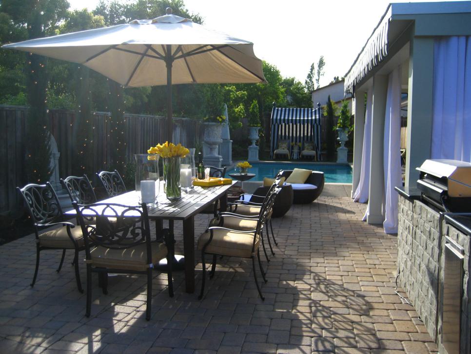 Outdoor Dining With Umbrella on Brick Patio Near Pool