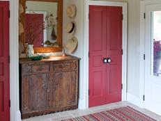 White Mudroom With Two Closets With Red Doors and Antique Dresser
