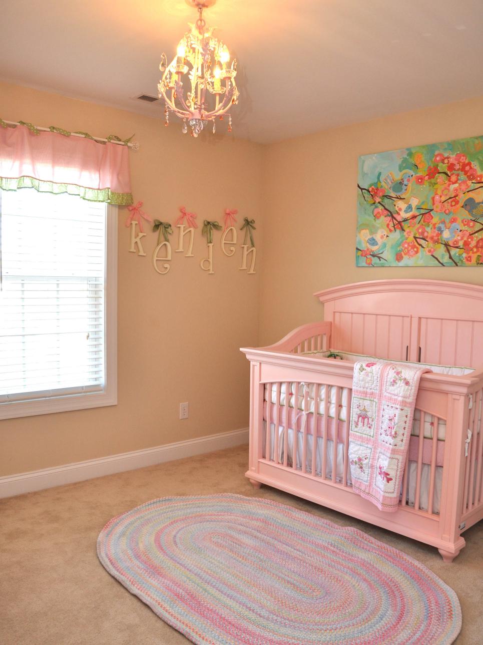 Girl's Nursery WIth Pink Wood Crib, Woven Area Rug and Multicolor Art