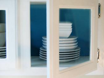 White cabinet doors with glass inserts, with blue interior. 