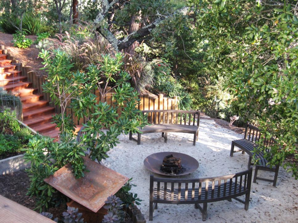 Outdoor Round Fire Pit Surrounded by Curved Benches in Garden Setting
