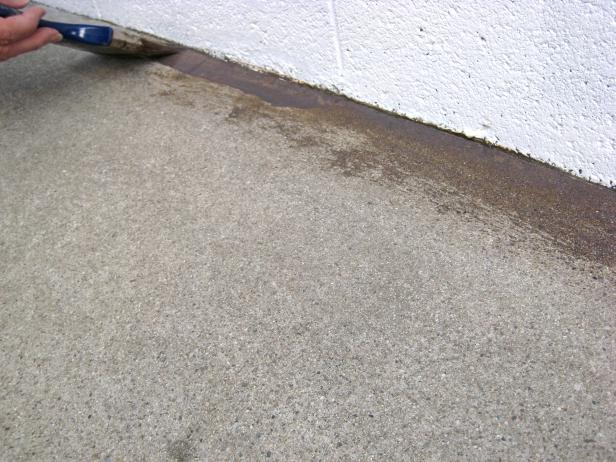 After the concrete has dried, you can begin applying the stain. Place your paint pan on the tarp and pour the stain into the pan. Using your paintbrush, apply the stain along the perimeter edge and at all seams.