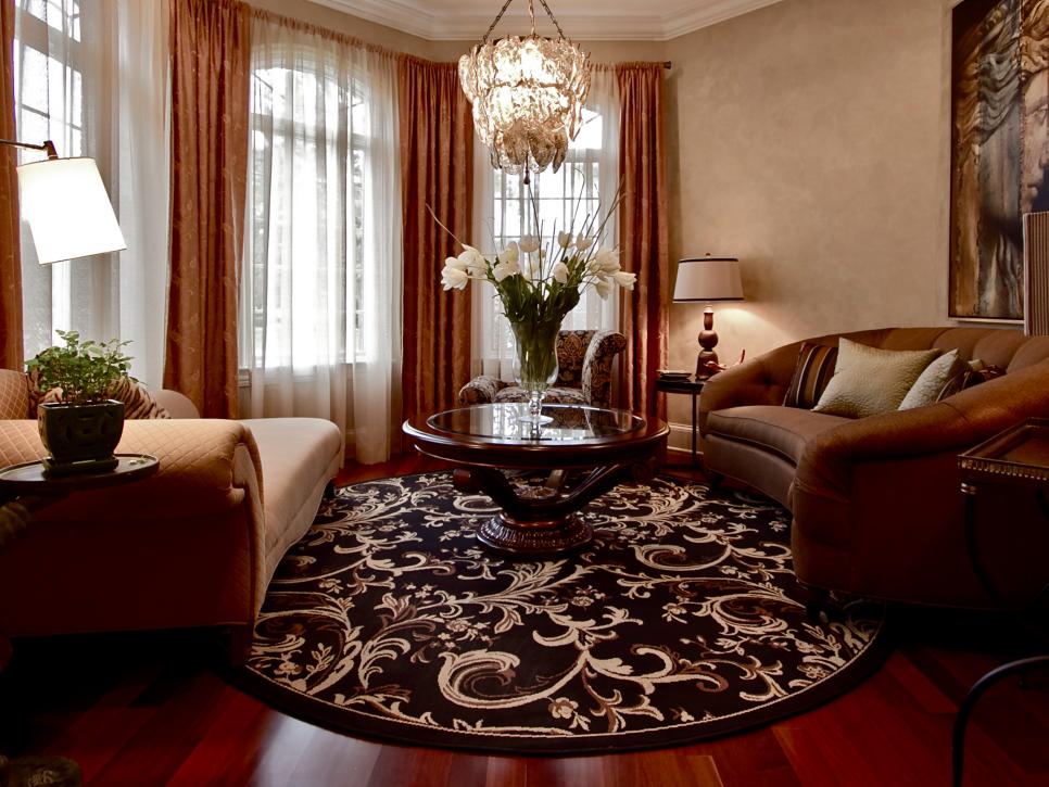 Brown Living Room With Chandelier and Round Area Rug