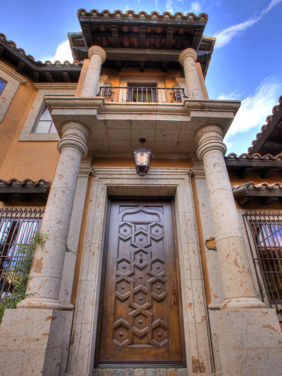 Exterior of Mediterranean Home With Columns, Balcony and Wood Door