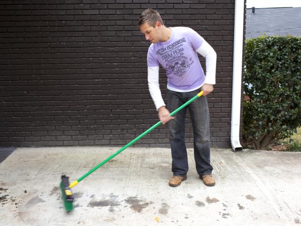 The first step in power washing a driveway is to clear debris and excess dirt or dust from its surface using a broom. This also prevents any loose material, such as small stones, to interfere with the pressure washer.