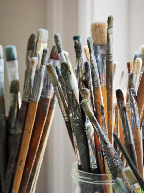 Paint brushes in different sizes with paint residue.